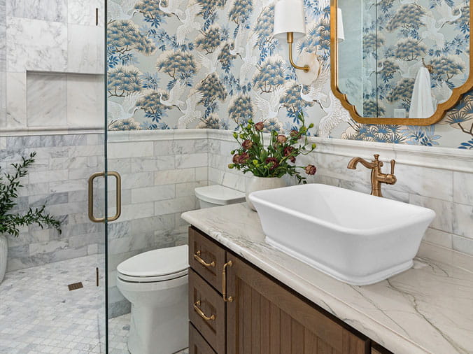 bathroom with floral wallpaper and brished brass faucet and hardware