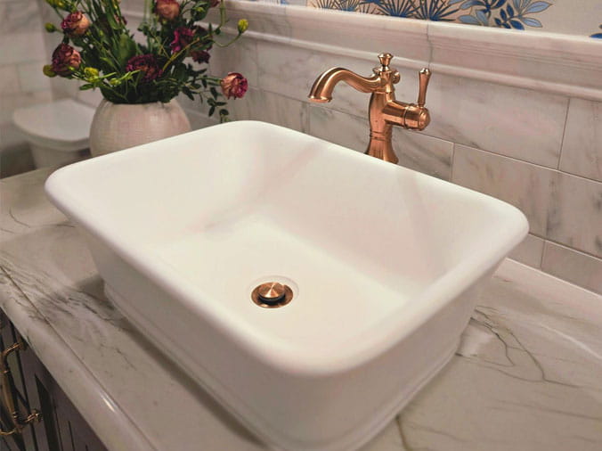 Bathroom sink basin with dark brass faucet and fittings